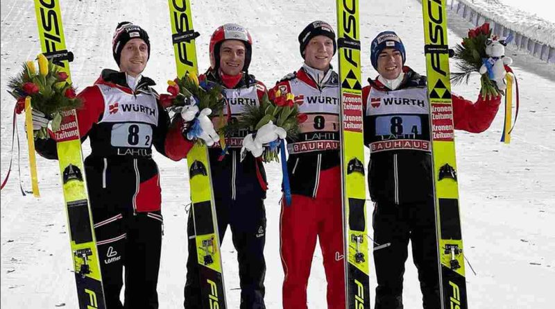 Czterech mężczyzn z nartami i bukietem kwiatów w rękach. Stoją na tle śniegu.