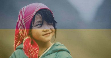 Uśmiechająca się dziewczynka na tle ukraińskiej flagi