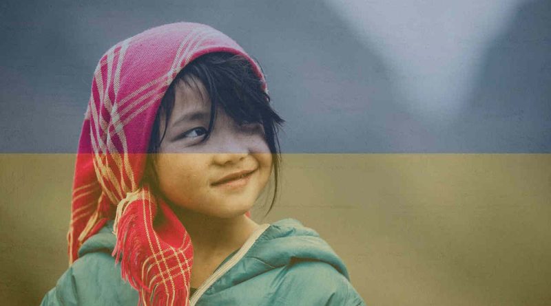 Uśmiechająca się dziewczynka na tle ukraińskiej flagi