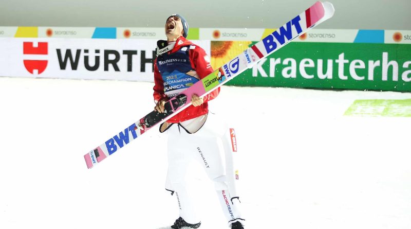 Skoczek narciarski bardzo uradowany, w rękach ma narty. Piotr Żyła - Mistrz Świata